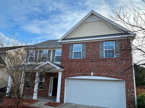 A two-story house with a garage door.