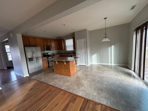 A kitchen with wooden cabinets and a tiled floor.