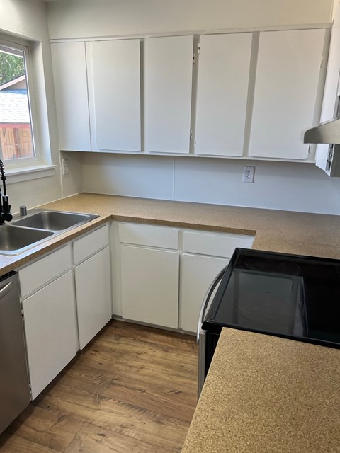 A kitchen with white cabinets and a black oven.