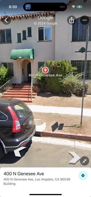 A black car is parked on the side of the street.