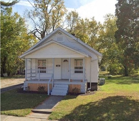 A small white house with a porch and a front door.