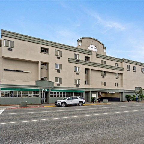 A large building with a car parked in front of it.