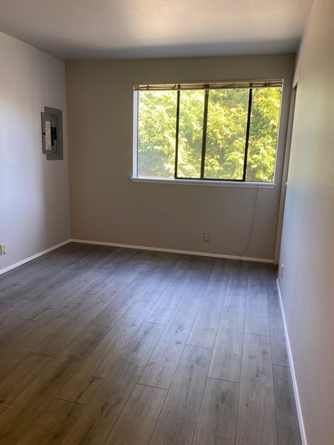 A room with a window and wooden flooring.