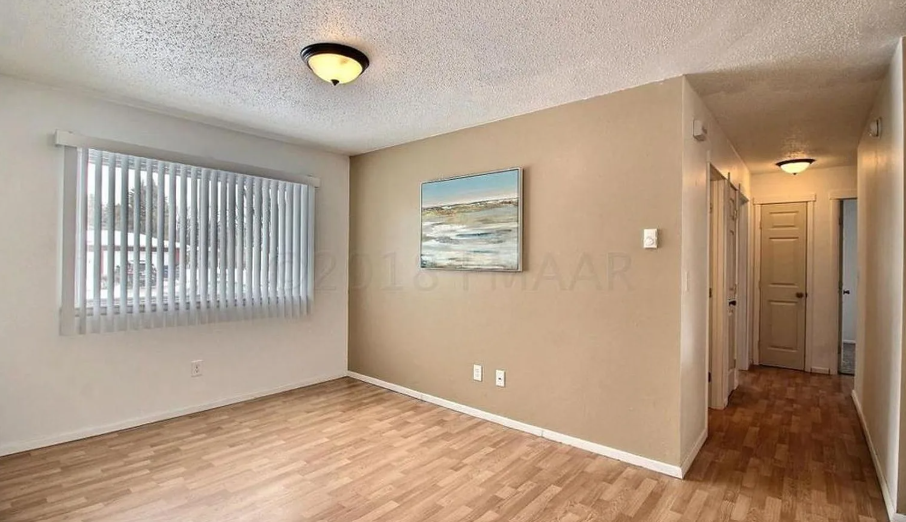 A room with a wooden floor and a painting on the wall.