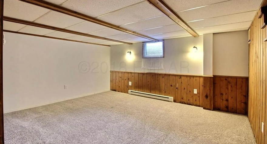 A room with a carpeted floor and wooden paneling on the walls.