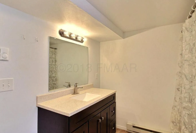 A bathroom with a sink and mirror.
