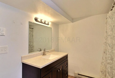 A bathroom with a sink and mirror.