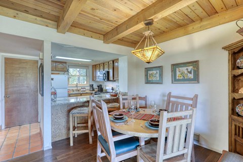 A wooden dining room with a table set for a meal.
