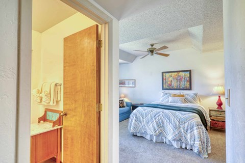 A bedroom with a bed and a ceiling fan.
