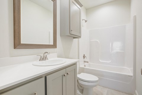 A white bathroom with a sink, toilet, and bathtub.