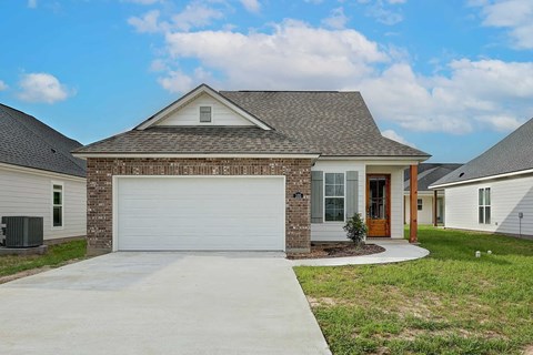 A house with a garage door and a brick wall.