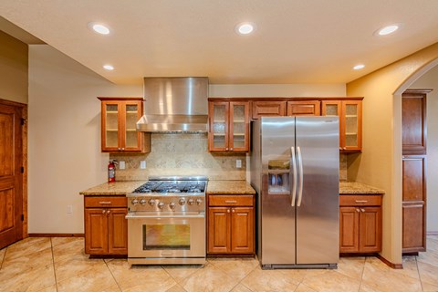 A kitchen with a stove top oven and a refrigerator.