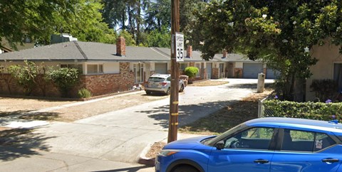 A blue car is parked on the side of a street.