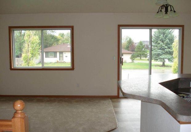 a living room with a kitchen and a large window