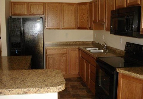 a kitchen with black appliances and granite counter tops