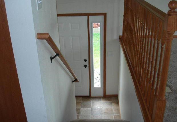 a hallway with stairs and a white door