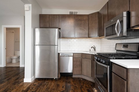 A modern kitchen with dark wood cabinets and stainless steel appliances.