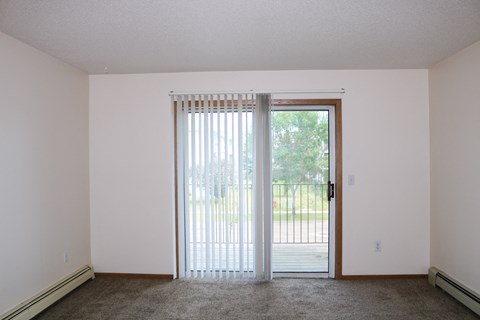 an empty living room with sliding glass doors to a patio