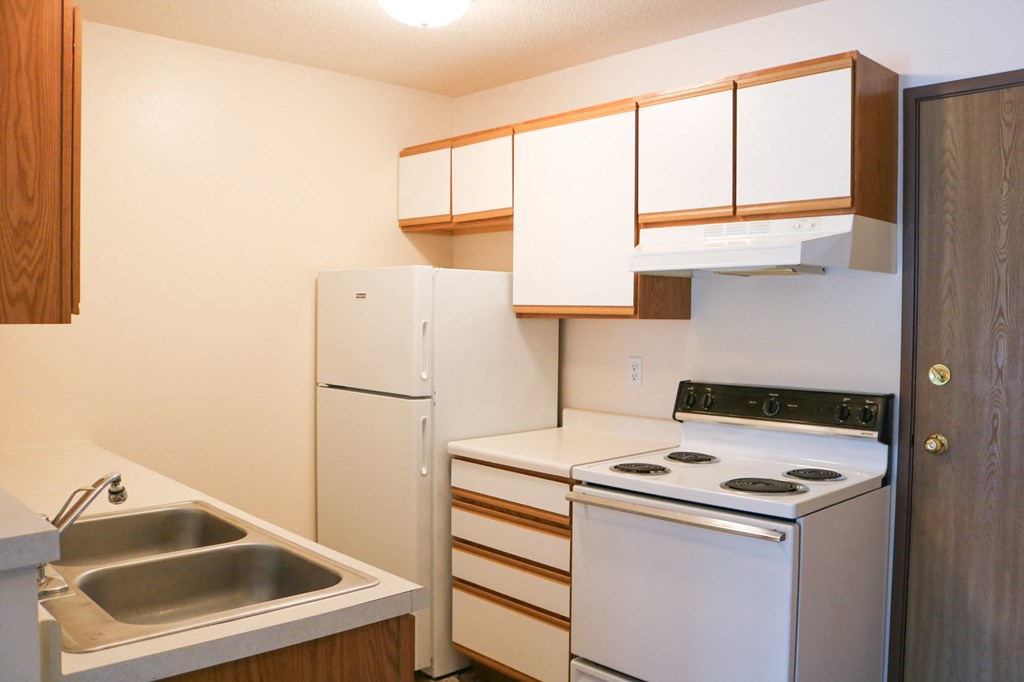 a kitchen with white appliances and a sink and a refrigerator