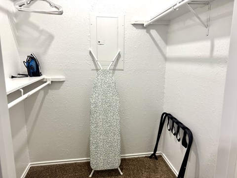 A white closet with a dress hanging in the middle.