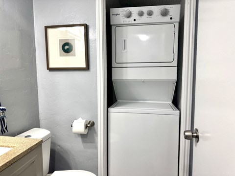 A white oven is in a bathroom next to a toilet.