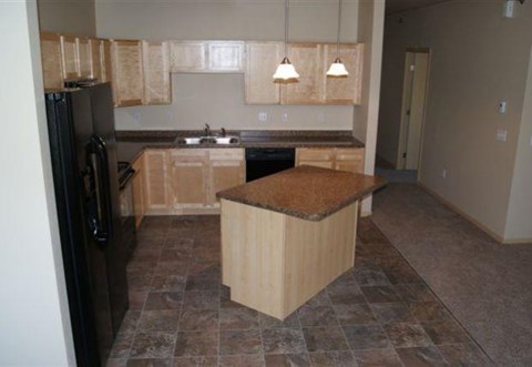 an empty kitchen with a counter top and a refrigerator