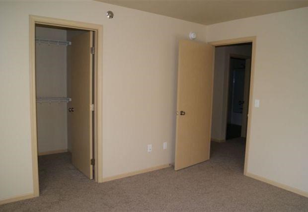 an empty room with a closet and two doors
