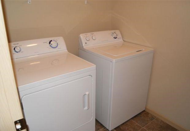 two washing machines in a room with a door