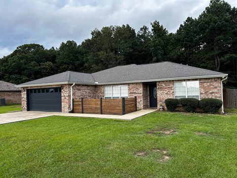 A house with a grey roof and a black garage door.