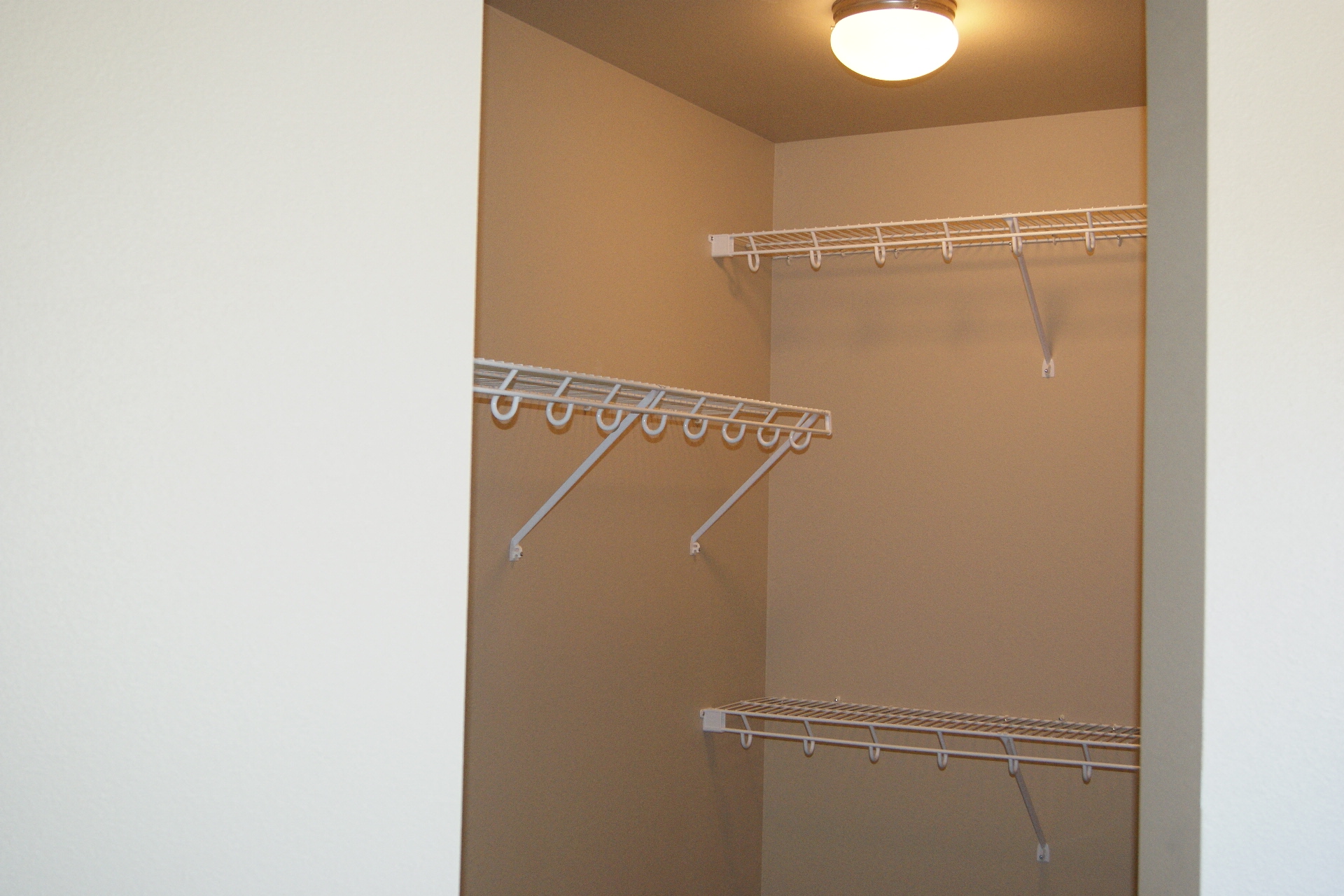 a walk in closet with a mirrored closet door and a hanging rack
