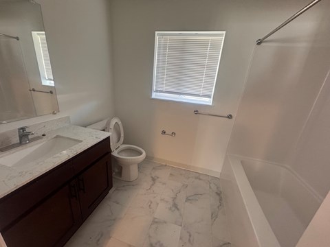 A bathroom with a marble floor and a white toilet.