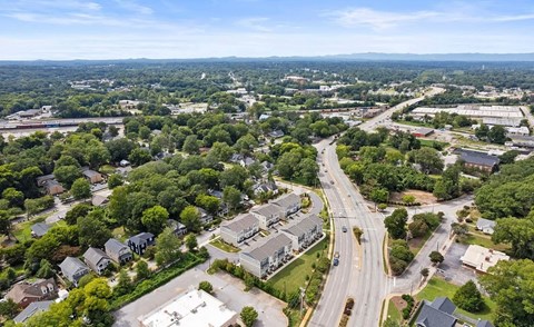 A bird's eye view of a suburban area with roads, houses, and trees.