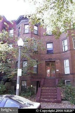 A red brick building with a tree in front of it.