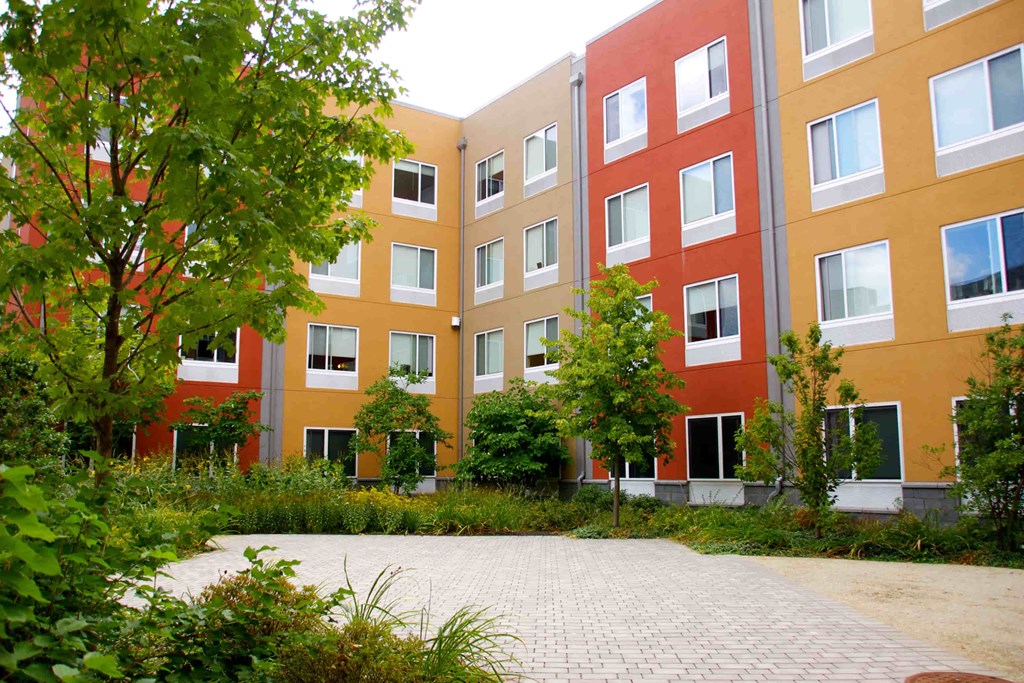 A multi-story building with a courtyard in front.