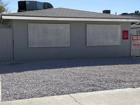 A house with a sign that says "For Rent" on the right side.