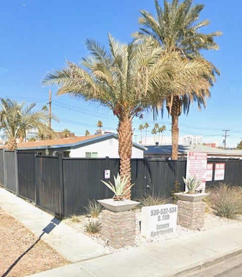 A palm tree stands in front of a sign for a funeral home.