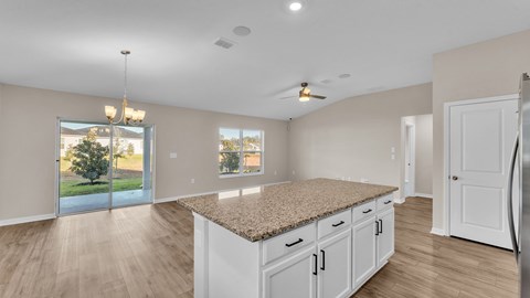 A kitchen with white cabinets and a granite countertop.