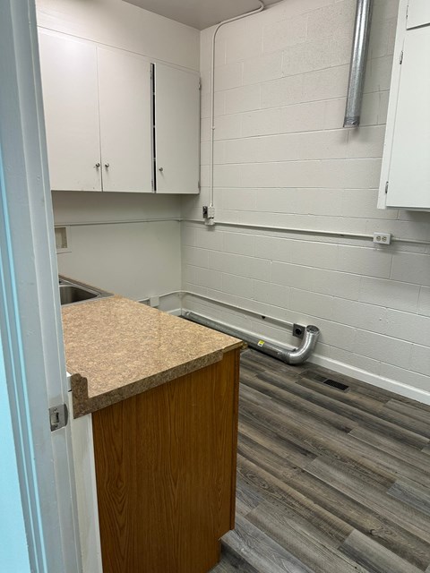 A kitchen with white cabinets and a wooden counter.