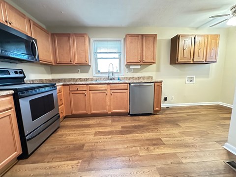 A kitchen with wooden cabinets and a black stove top oven.