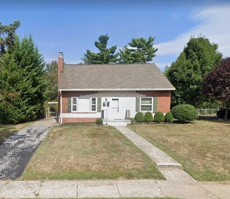 A small house with a white door and a brick chimney.