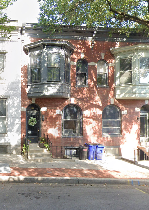 A red brick building with a black door and windows.