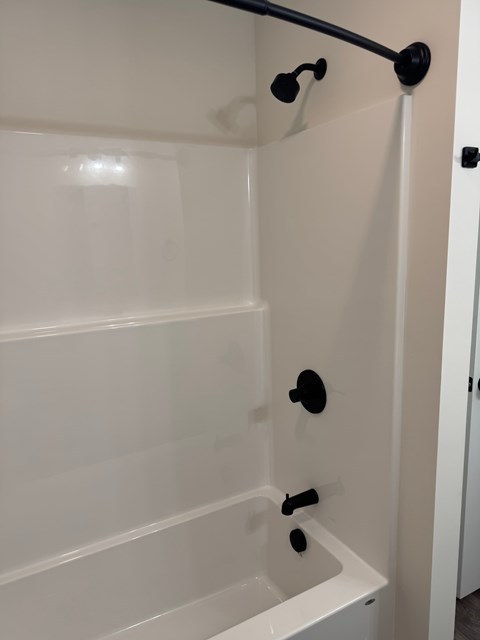 A white bathroom with a shower and a door.