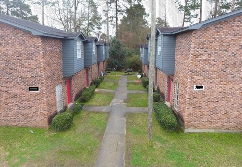 A long row of houses with a path in the middle.