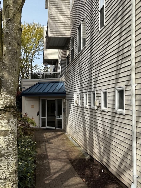 A building with a blue roof and a tree in front.