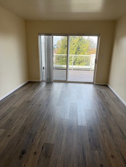 A room with a sliding glass door leading to a parking lot.