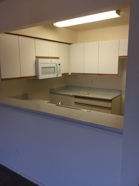 A kitchen with a microwave oven on the counter.