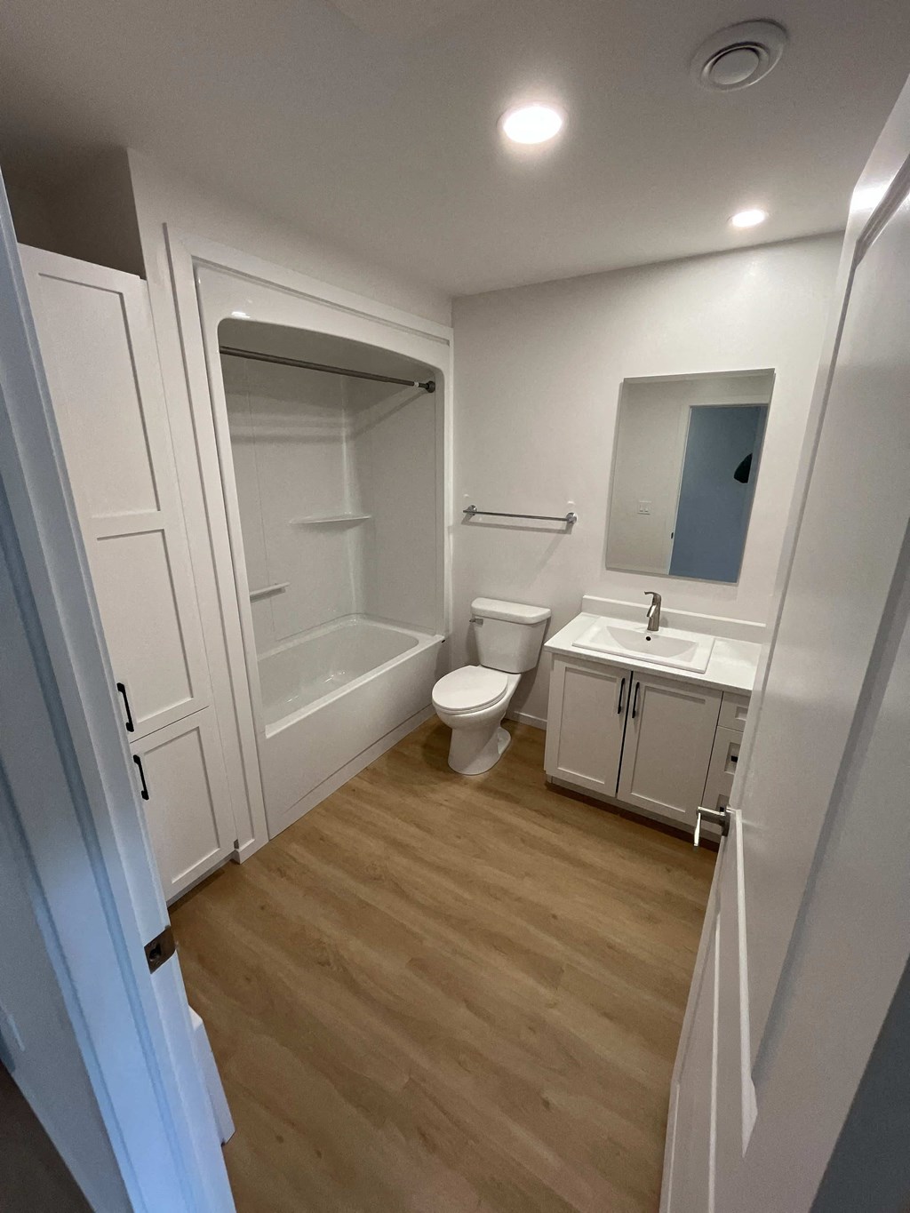 A white bathroom with a toilet, sink, and shower.