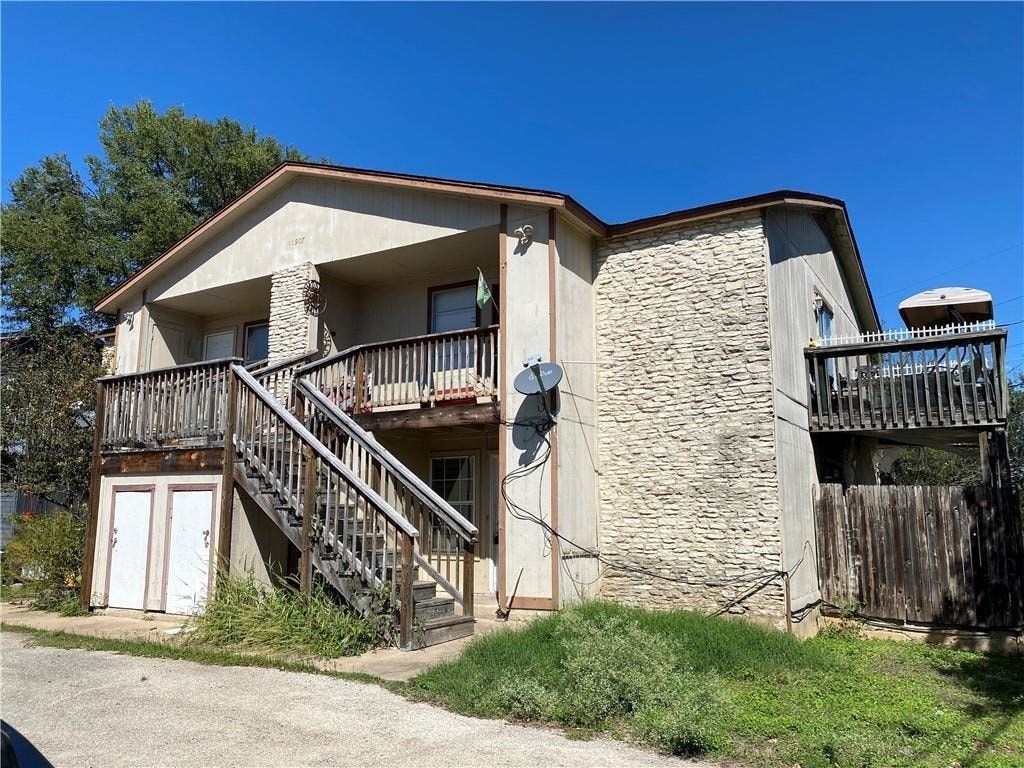 A two-story house with a balcony and a satellite dish on the roof.