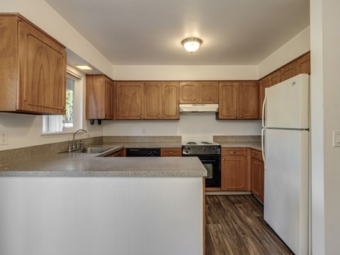 A kitchen with wooden cabinets and a white refrigerator.