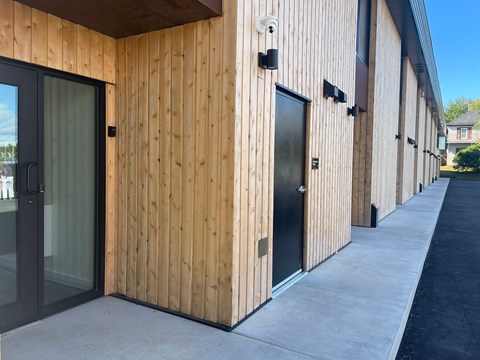 A building with wooden walls and black doors.